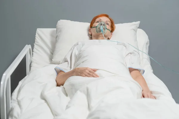 Пожилая женщина дышит в кислородной маске — стоковое фото