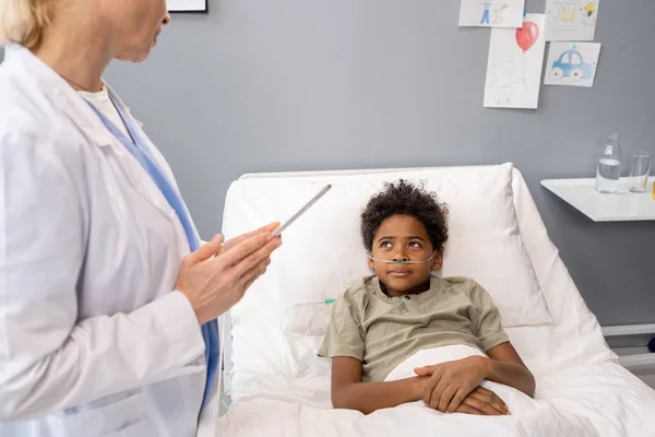 Niño pequeño hablando con el doctor en el hospital — Foto de Stock