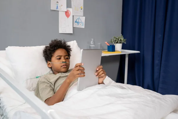 Мальчик, использующий планшетный компьютер в больнице — стоковое фото
