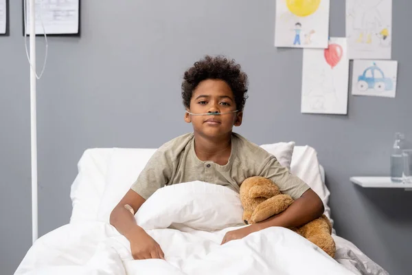 Menino sentado na cama do hospital — Fotografia de Stock