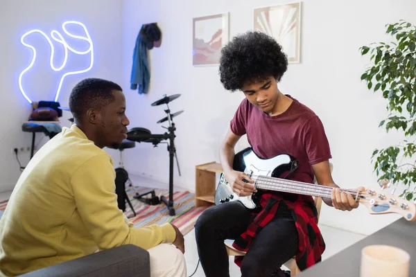 Muziekleraar consulting biracial guy met gitaar — Stockfoto