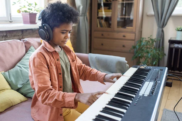 Piyano klavyesinin tuşlarına basan çalışkan çocuk — Stok fotoğraf