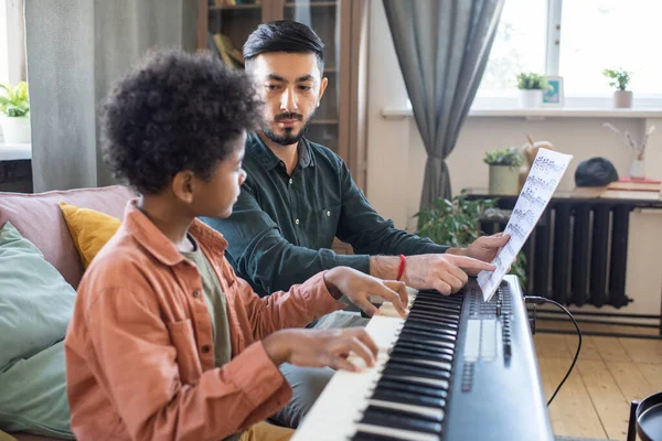 Notalarla notaları gösteren genç müzik öğretmeni — Stok fotoğraf