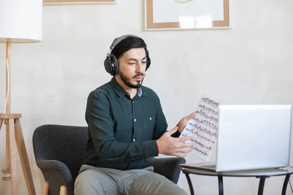 Kulaklıklı genç müzik öğretmeni çevrimiçi izleyicilerle iletişim kuruyor. — Stok fotoğraf