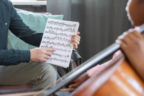 Hand der jungen Musiklehrerin zeigt auf Notenblatt — Stockfoto