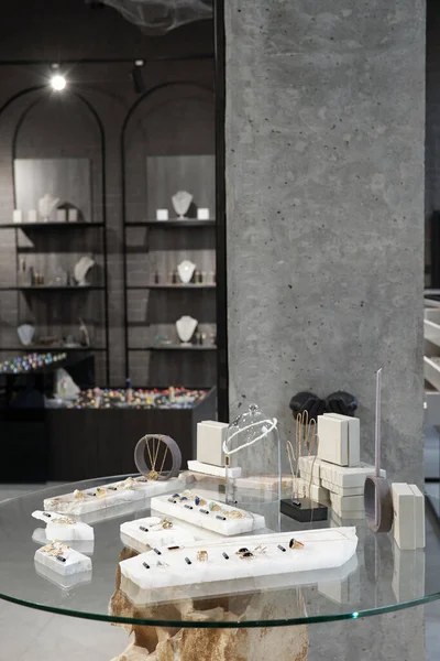 Mesa de vidro com nova coleção de jóias no fundo de outras exposições — Fotografia de Stock