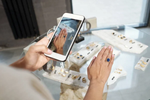 Hand of young woman trying on ring with blue gemstone — Stock Photo, Image