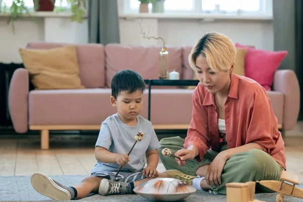 Junge Frau bringt ihrem kleinen Sohn das Handpan-Spiel bei — Stockfoto