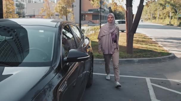 Mujer Musulmana Hijab Atuendo Casual Caminando Estacionamiento Subiendo Auto Sentada — Vídeo de stock