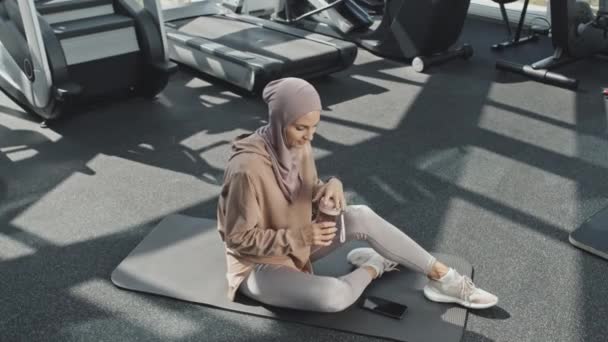 Yüksek Açılı Çekimde Tesettürlü Müslüman Bir Kadın Spor Salonunda Yerde — Stok video