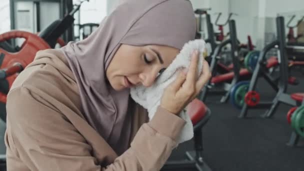 Obróć Dół Ujęcie Pięknej Muzułmanki Hidżabie Odzieży Sportowej Wycierając Czoło — Wideo stockowe