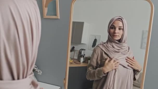 Junge Schöne Muslimin Trägt Blassrosa Hijab Schaut Den Spiegel Und — Stockvideo