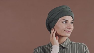 Fotoğraf makinesine poz veren tesettürde gülümseyen güzel Müslüman kadın portresi