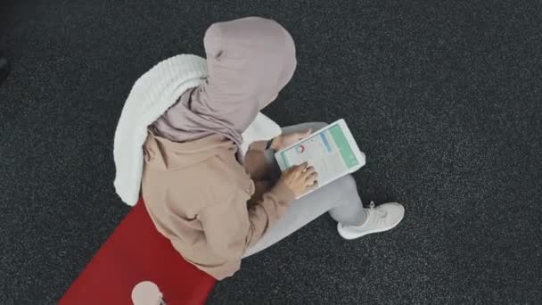 히잡을 체육관에 수건으로 얼굴을 디지털 태블릿에서 통계를 확인하는 이슬람 여성의 — 비디오