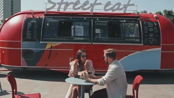 Młoda Kaukaska Para Siedzi Przy Stole Obok Czerwonej Ciężarówki Jedzeniem — Wideo stockowe