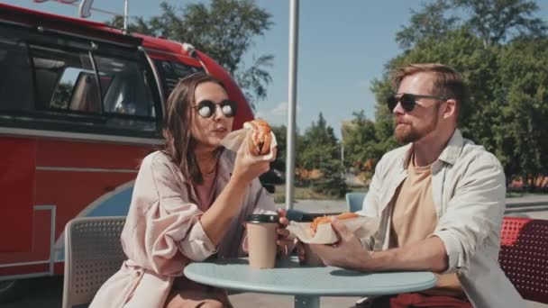 Medium Shot Young Caucasian Couple Eating Hotdogs Coffee Having Conversation — 图库视频影像