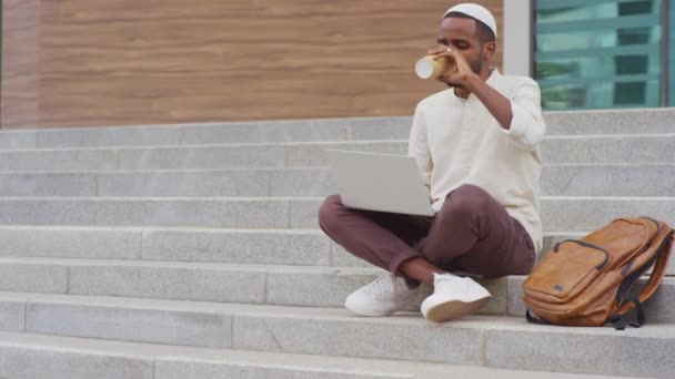 Повний Знімок Молодого Чорношкірого Куфі Використовуючи Ноутбук Каву Паперової Чашки — стокове відео