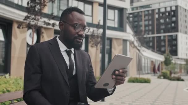 Medium Shot African American Businessman Suit Glasses Sitting Bench Drinking — 图库视频影像