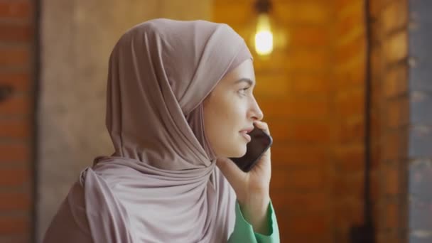 Schouder Van Jonge Blanke Moslimvrouw Dragen Hijab Praten Mobiele Telefoon — Stockvideo