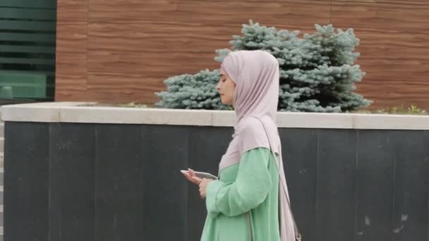 Tracking Side View Young Caucasian Muslim Woman Wearing Hijab Holding — 图库视频影像