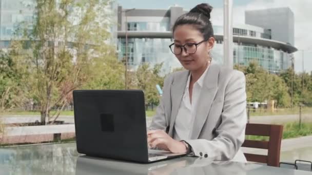Tracking Shot Cheerful Asian Businesswoman Formal Wear Glasses Working Laptop — Stock Video
