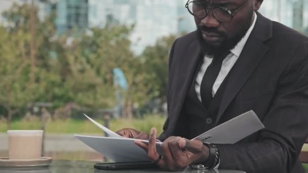 공식적 안경을 아프리카 미국인 사업가와 카페에서 테이블에 문서가 파일을 — 비디오