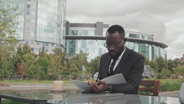 Közepes Felvételű Afro Amerikai Üzletember Öltönyben Szemüvegben Asztalnál Szabadtéri Kávézóban — Stock videók