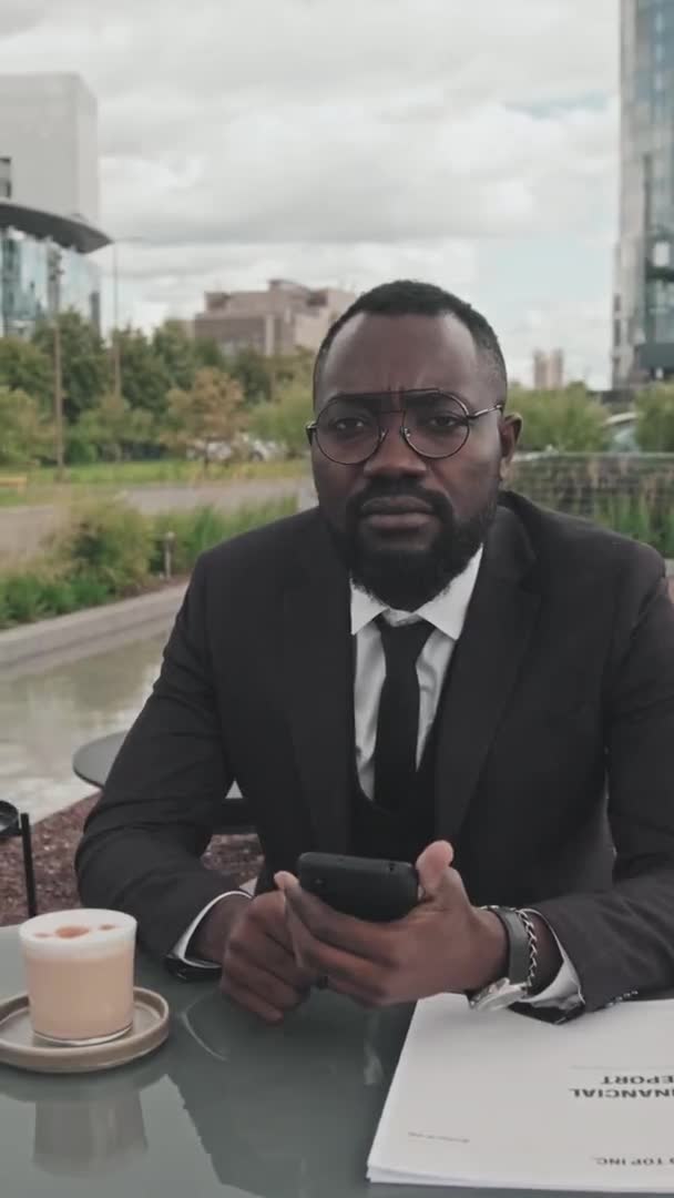 Pionowy Portret Śledzeniem Afroamerykańskiego Biznesmena Garniturze Okularach Trzymającego Telefon Komórkowy — Wideo stockowe