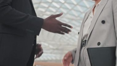 Tanımlanamayan iş adamı ve iş kadınının lobide iş görüşmeleri ve el sıkışma faslını kapatın.
