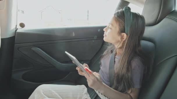 Ruční Záběr Devítileté Dívky Úsměvem Pomocí Tabletu Při Jízdě Zadním — Stock video
