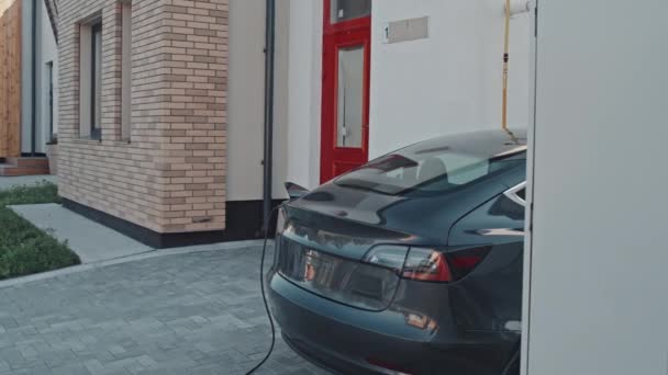 Tracking Lövés Modern Elektromos Autó Parkolt Ház Mellett Kertvárosban Töltés — Stock videók