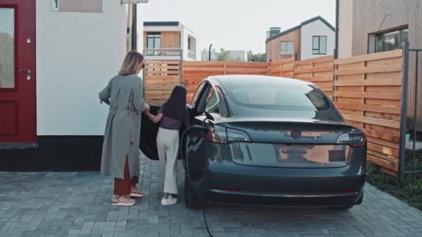 Seguimiento Tiro Joven Madre Elegante Desenchufar Coche Eléctrico Del Cargador — Vídeos de Stock