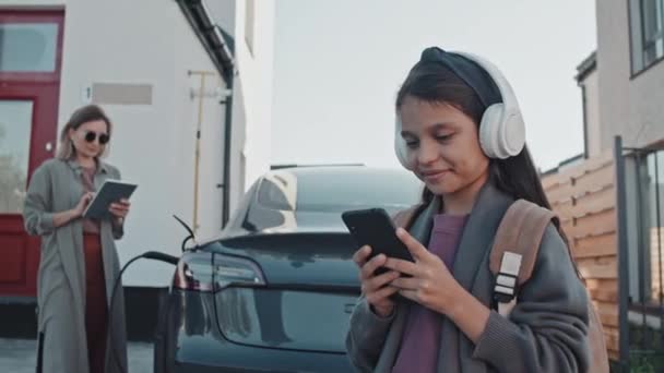 Śledzenie Szczęśliwej Letniej Dziewczynki Słuchawkach Pomocą Telefonu Komórkowego Podczas Gdy — Wideo stockowe