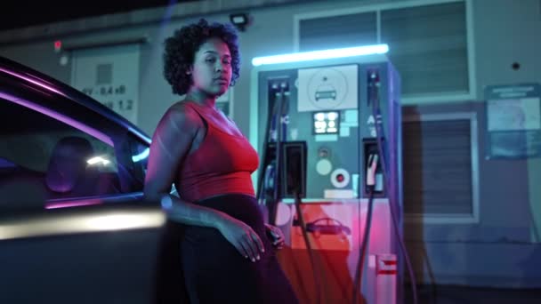 Genç Afro Amerikalı Bir Kadının Elektrikli Arabasına Yaslanırken Şarj Istasyonunda — Stok video
