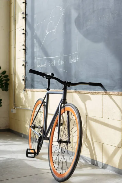 Fiets van witte boord arbeider stand by schoolbord — Stockfoto