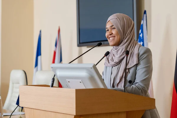 Νεαρή επιτυχημένη Μουσουλμάνα επιχειρηματίας με χιτζάμπ στέκεται δίπλα στον Τριβούνο. — Φωτογραφία Αρχείου