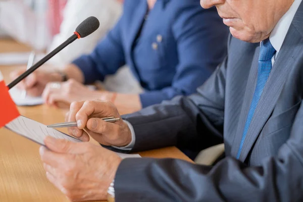 Hände eines reifen Delegierten zeigen auf Dokument in der Zwischenablage — Stockfoto