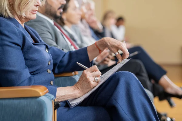 Rij van buitenlandse afgevaardigden die luisteren naar de lezing en aantekeningen maken — Stockfoto