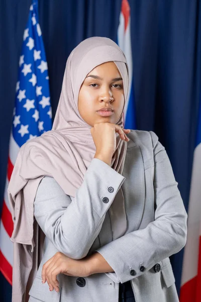 Молодая серьезная женщина в хиджабе и формальной одежде смотрит на тебя — стоковое фото