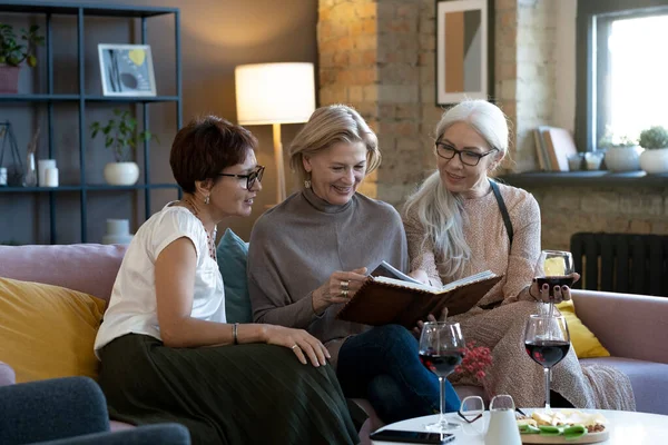 Fotoğraf albümündeki fotoğraflara bakan arkadaşlar