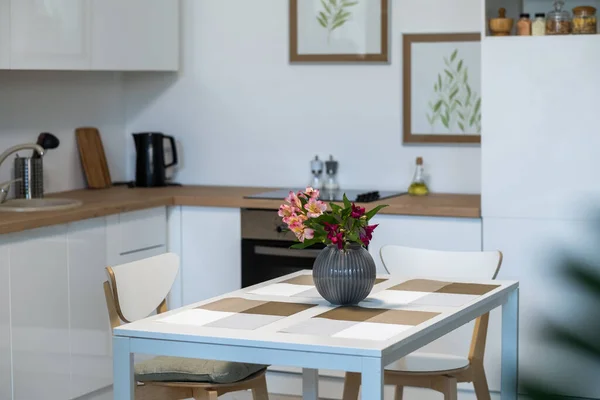 Flowers in vase on the kitchen table - Stock-foto