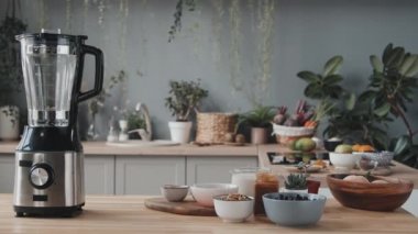 Mutfak tezgahının üzerinde smoothie malzemeleri olan karıştırıcı ve kâselerin izini sürüyorum.