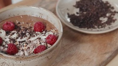 Sağlıklı ve lezzetli meyve suyu kasesini naneyle süsleyen tanınmayan bir kadının PAN yakın çekimi.