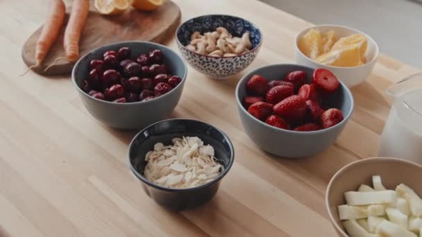 Handheld Close Shot Van Verse Ingrediënten Keukentafelbessen Fruit Noten Kommen — Stockvideo