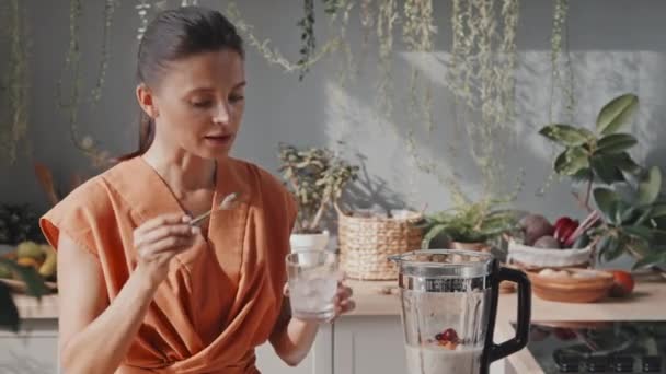 Śledzenie Średniego Ujęcia Wesołej Młodej Kobiety Robi Pyszne Smoothie Kuchni — Wideo stockowe