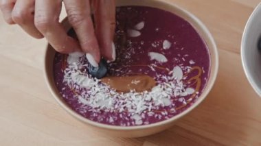 Tanımlanamayan genç bir kadının el ele tutuşması lezzetli meyve sularını yaban mersinleriyle süslemesi.