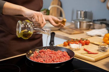 Kıymaya zeytin yağı katan genç bir kadının elleri