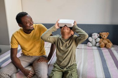 Mutlu genç adam gülümseyerek küçük şirin bir çocuğa bakıyor.