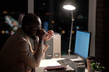 Genç ve yorgun işadamı kanal boyunca yüzüne dokunuyor.