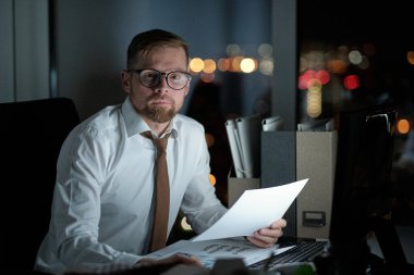 Finansal belgelere bakan ciddi bir ofis çalışanı.